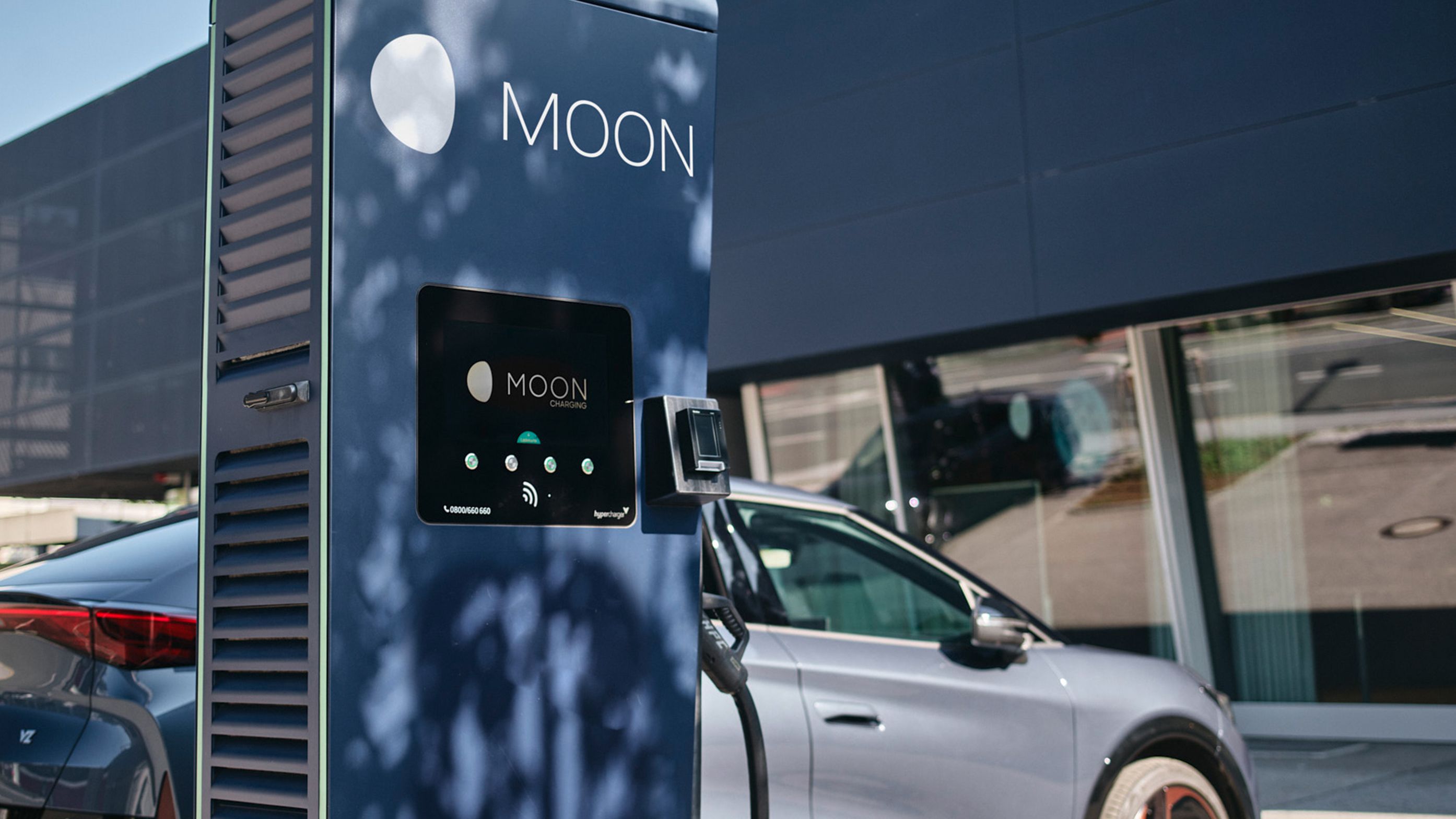 Töltőállomás egy autó előtt, kijelzővel