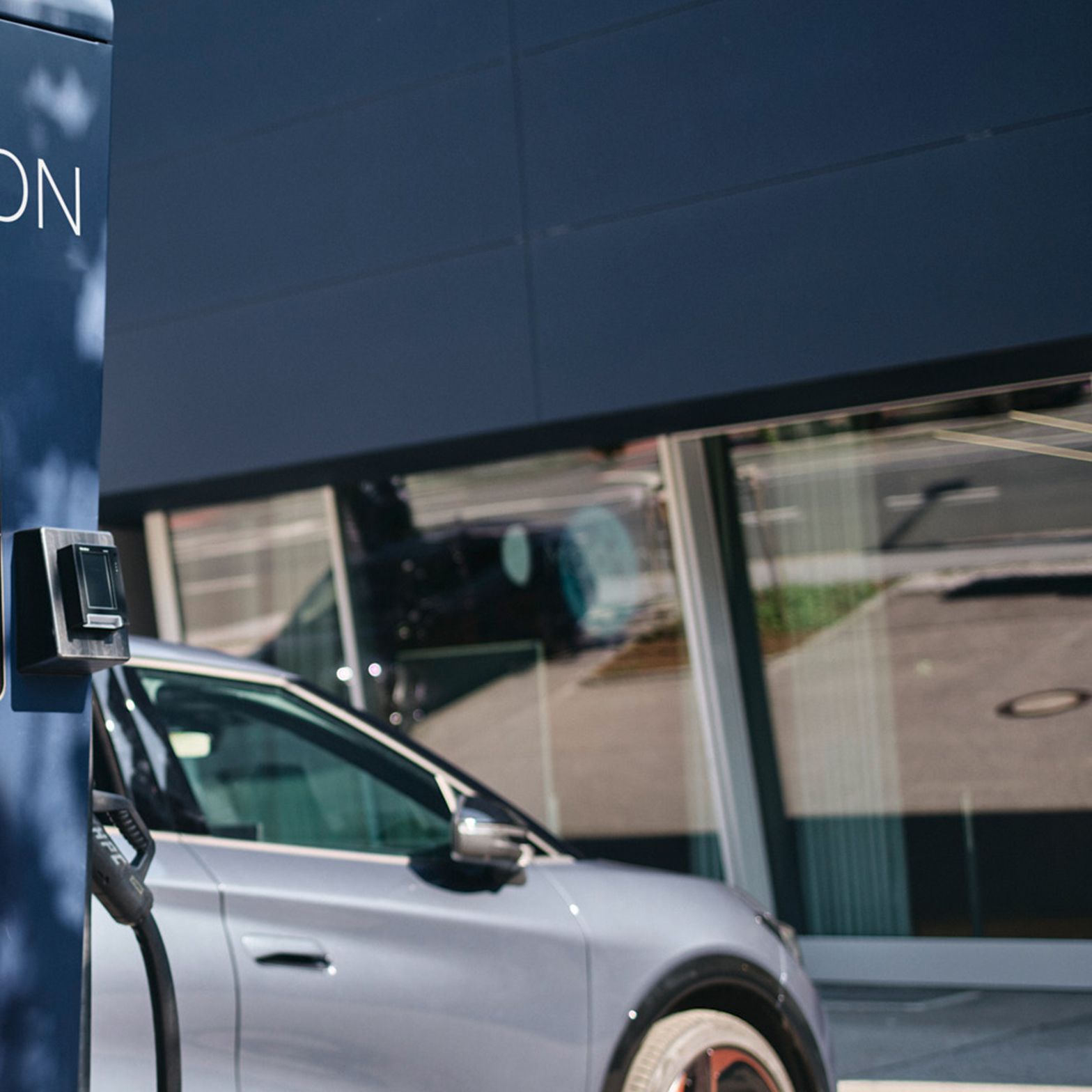 Töltőállomás egy autó előtt, kijelzővel