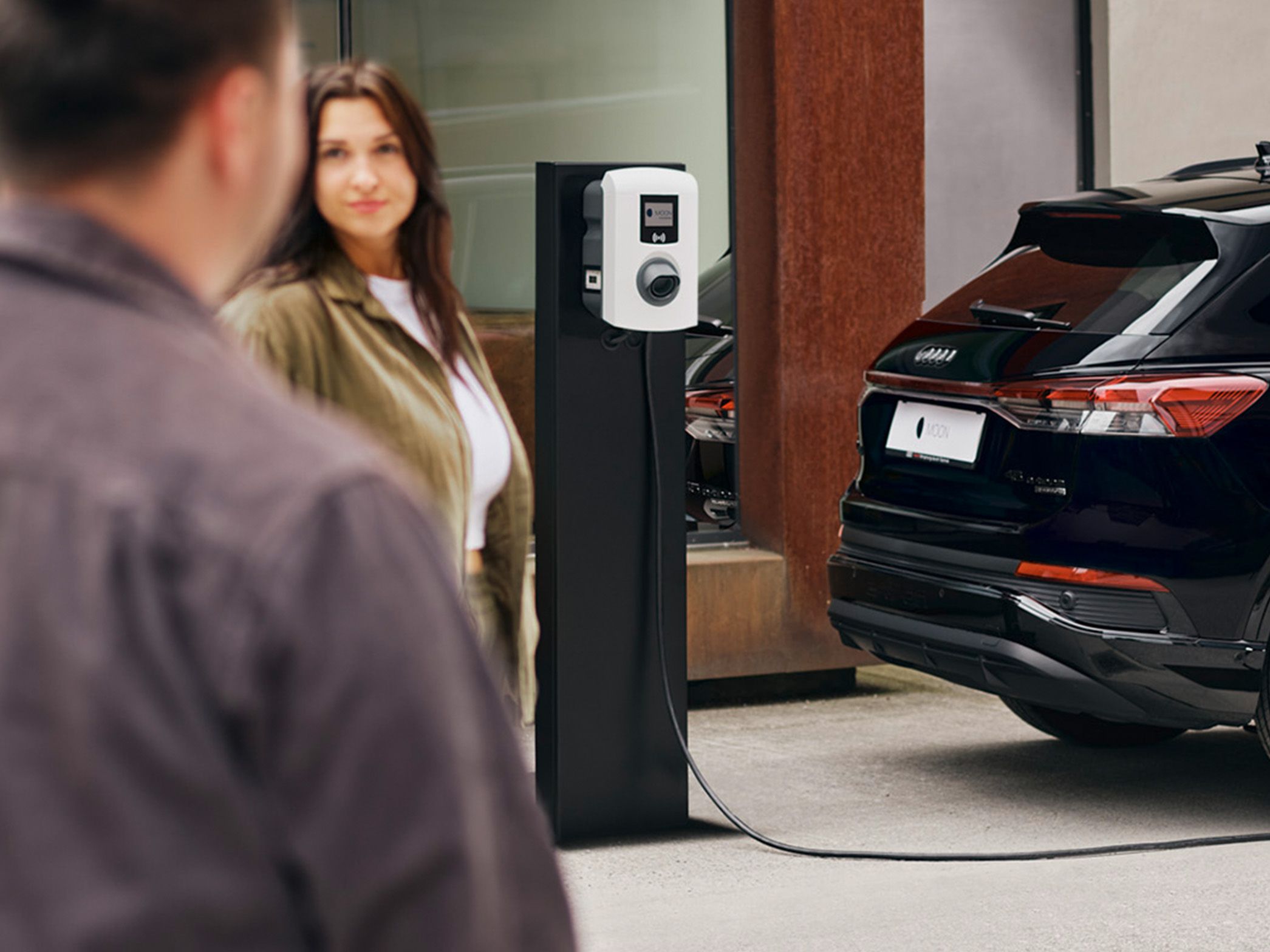 Egy autó töltőállomásnál rohamol, két ember az előtérben