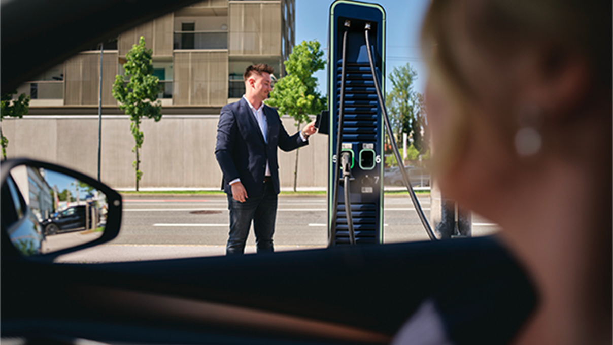 Az ember kártyát tart egy töltőállomáshoz