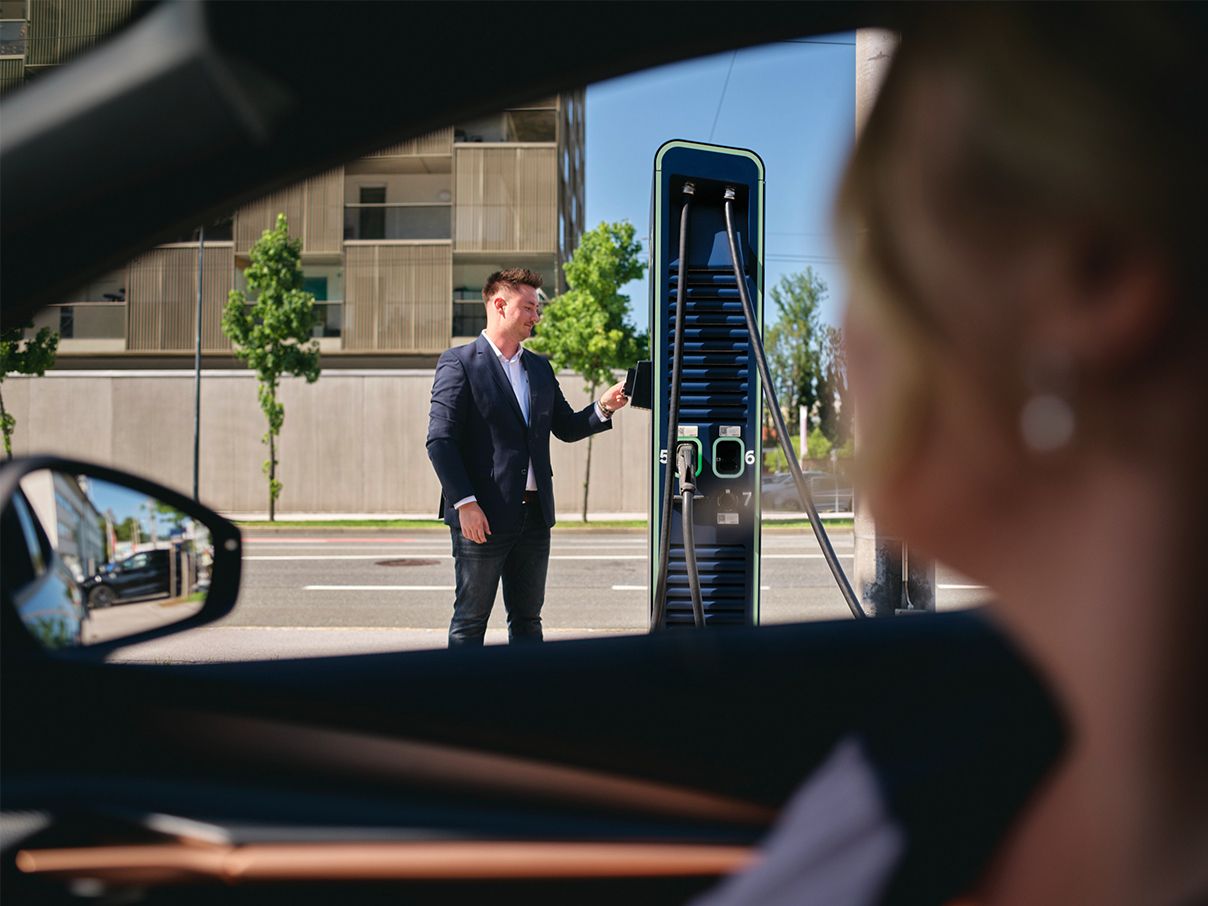 Az ember kártyát tart egy töltőállomáshoz