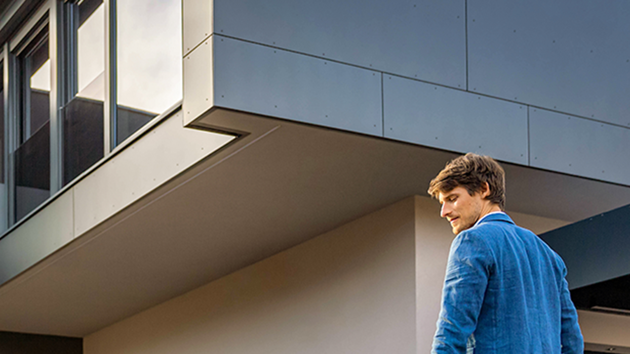 Az ember egy autó felé sétál kábellel a kezében