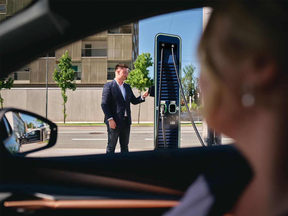 A személy kártyával fizet egy töltőállomáson