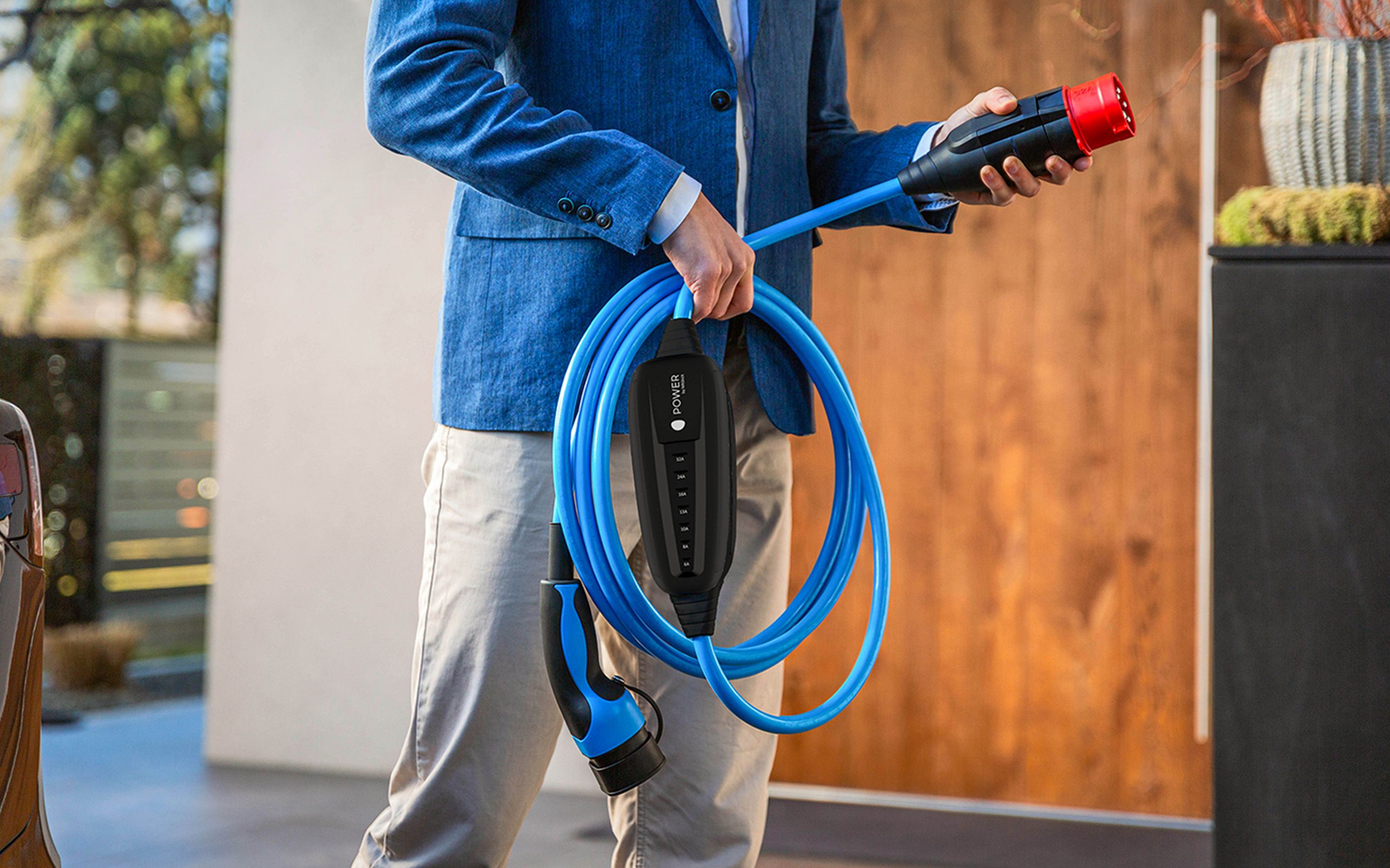 Egy férfi tartja a kezében egy kábel dugóját